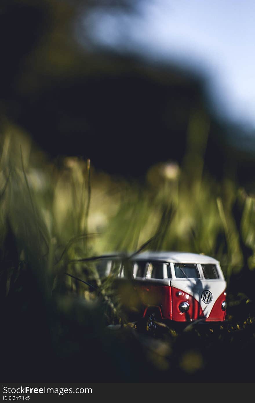 Shallow Focus Photography of White and Red Volkswagen Samba Die-cast Model