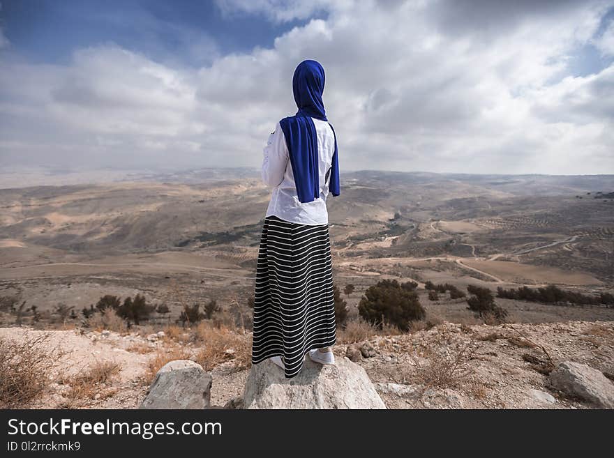 Woman Standing Near Beige Cliff