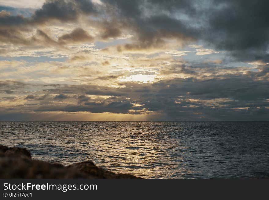 Sea Under Gray Cloudy Sky during Dawn