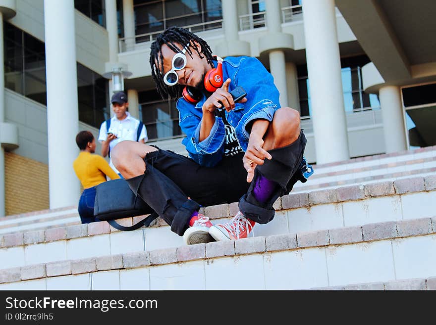 Photo of Man Wearing Blue Jacket Sitting on Stairs