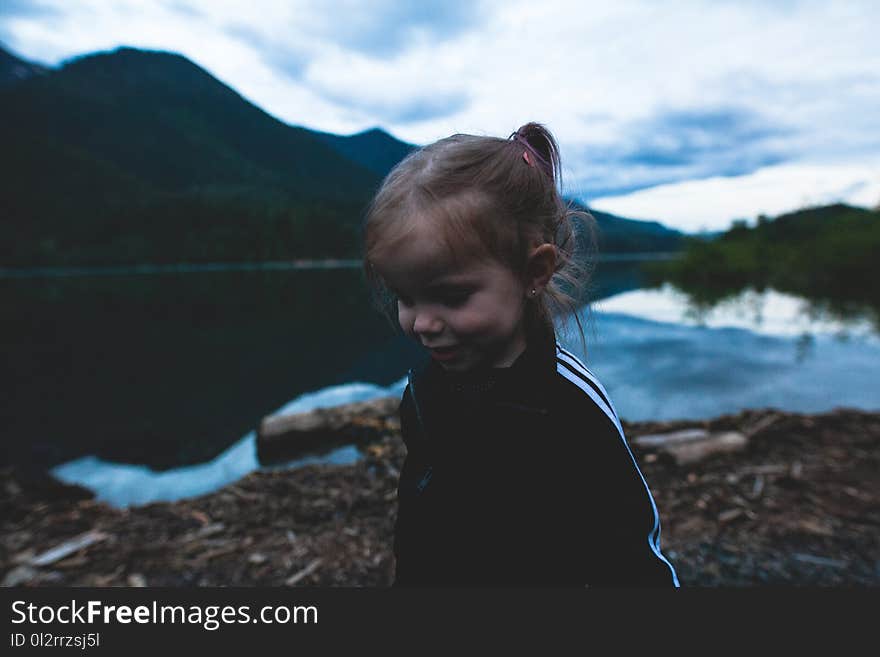 Girl Wearing Black and White Track Jacket Near Body of Water