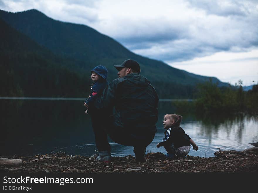 Man With Two Kids Near Body of Water