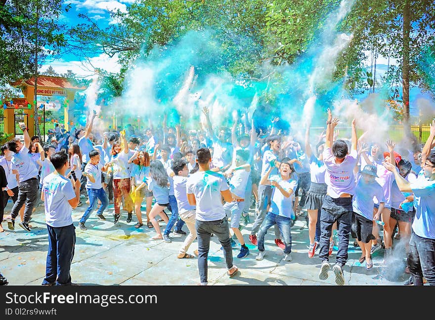 People Throwing Blue Powder at Daytime