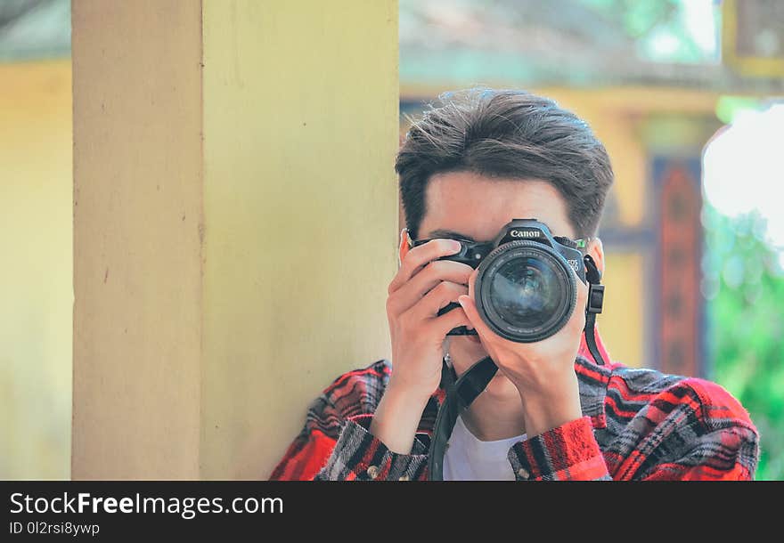 Man Holding Black Canon Dslr Camera Taken