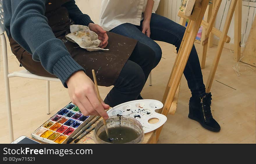 Art teacher and her apprentice working on a watercolor picture. Professional shot on Lumix GH4 in 4K resolution. You can use it e.g. in your commercial video, business, presentation, broadcast video.