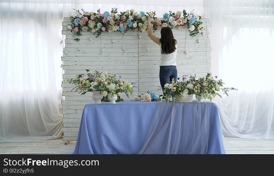 Beautiful florist creating spring colorful bouquet arrangement. Flowers event wedding decoration. Process of preparing floral composition for celebrating party.