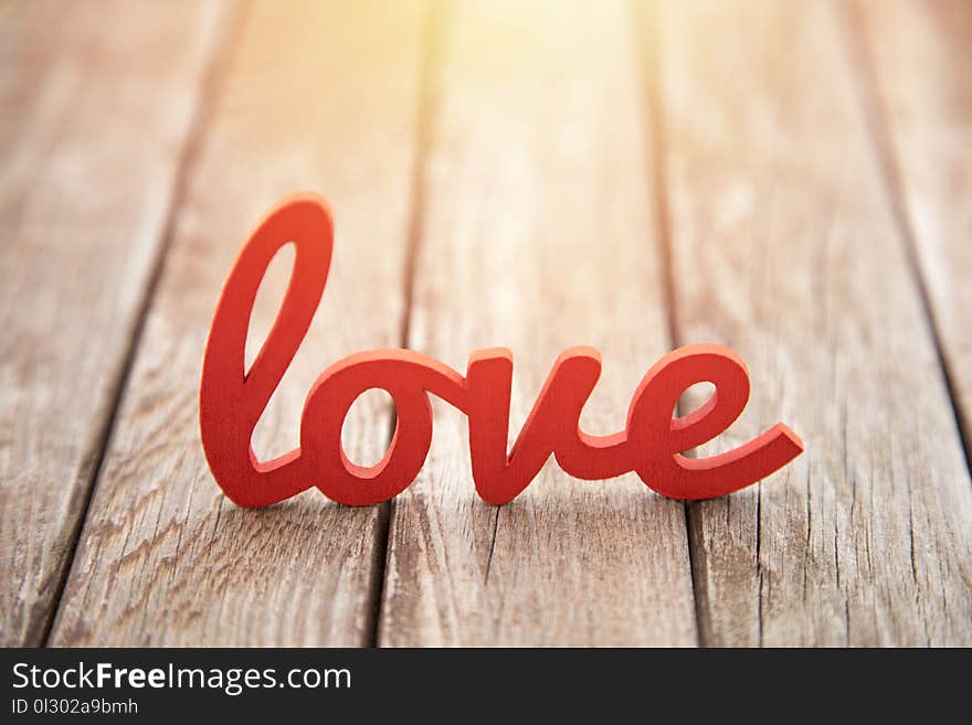 Word love on wooden background in sunset