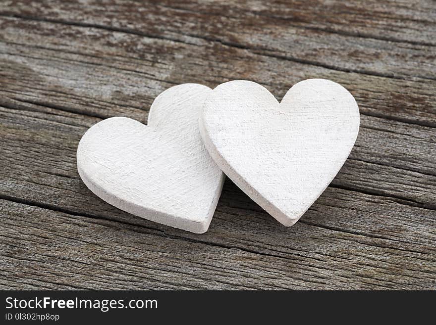 Two hearts on wooden background