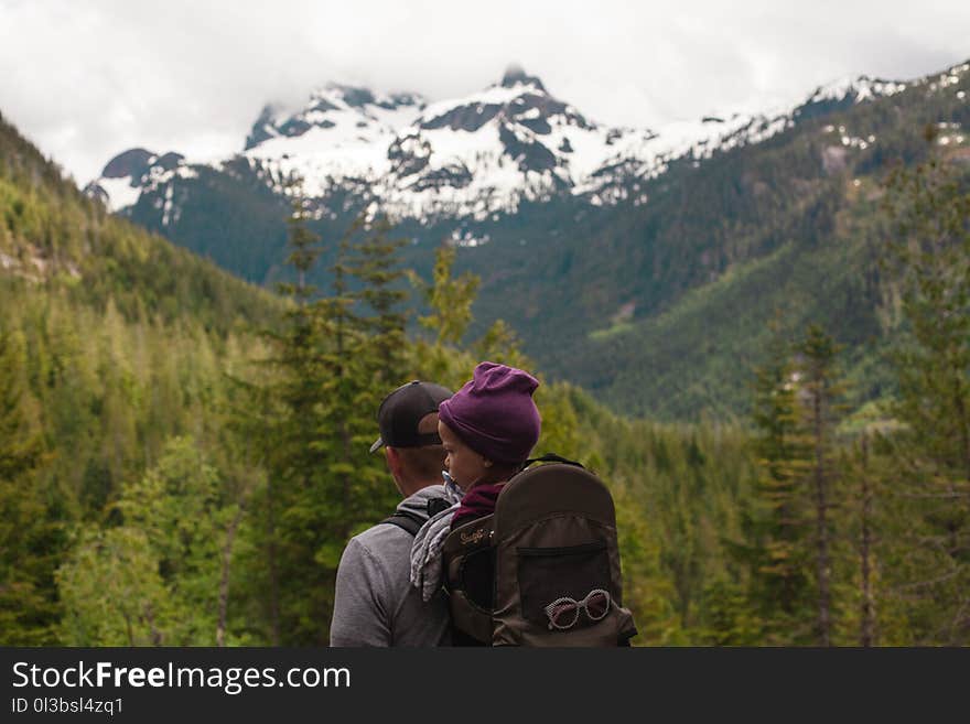 Man Carrying Baby With Brown Baby Carrier Near Trees