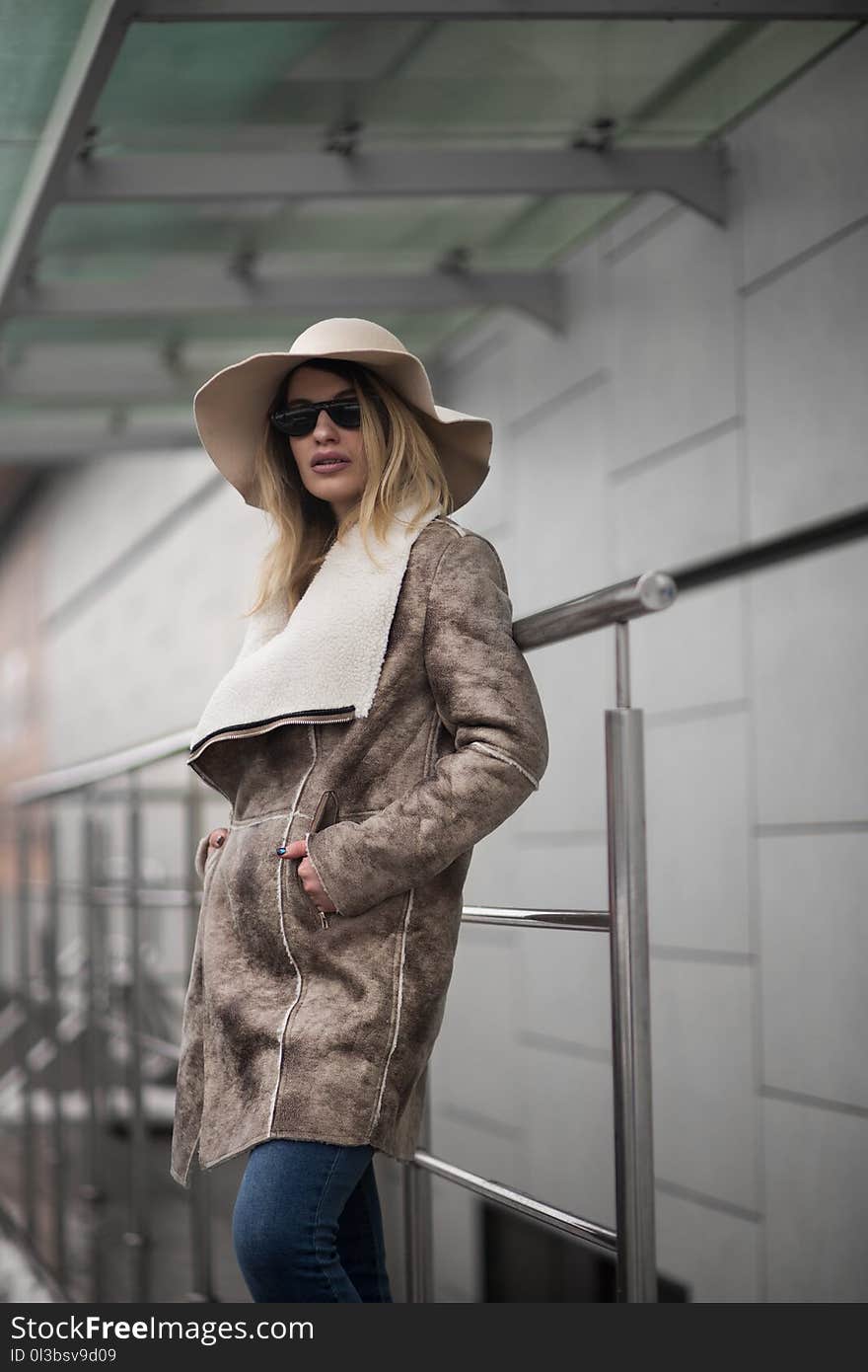 Woman in Brown Suede Coat and Sun Hat