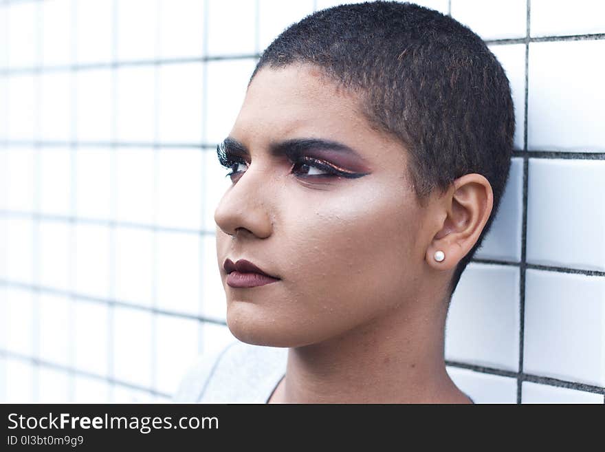 Woman Wearing Stud Earrings Leaning White Tiled Wall