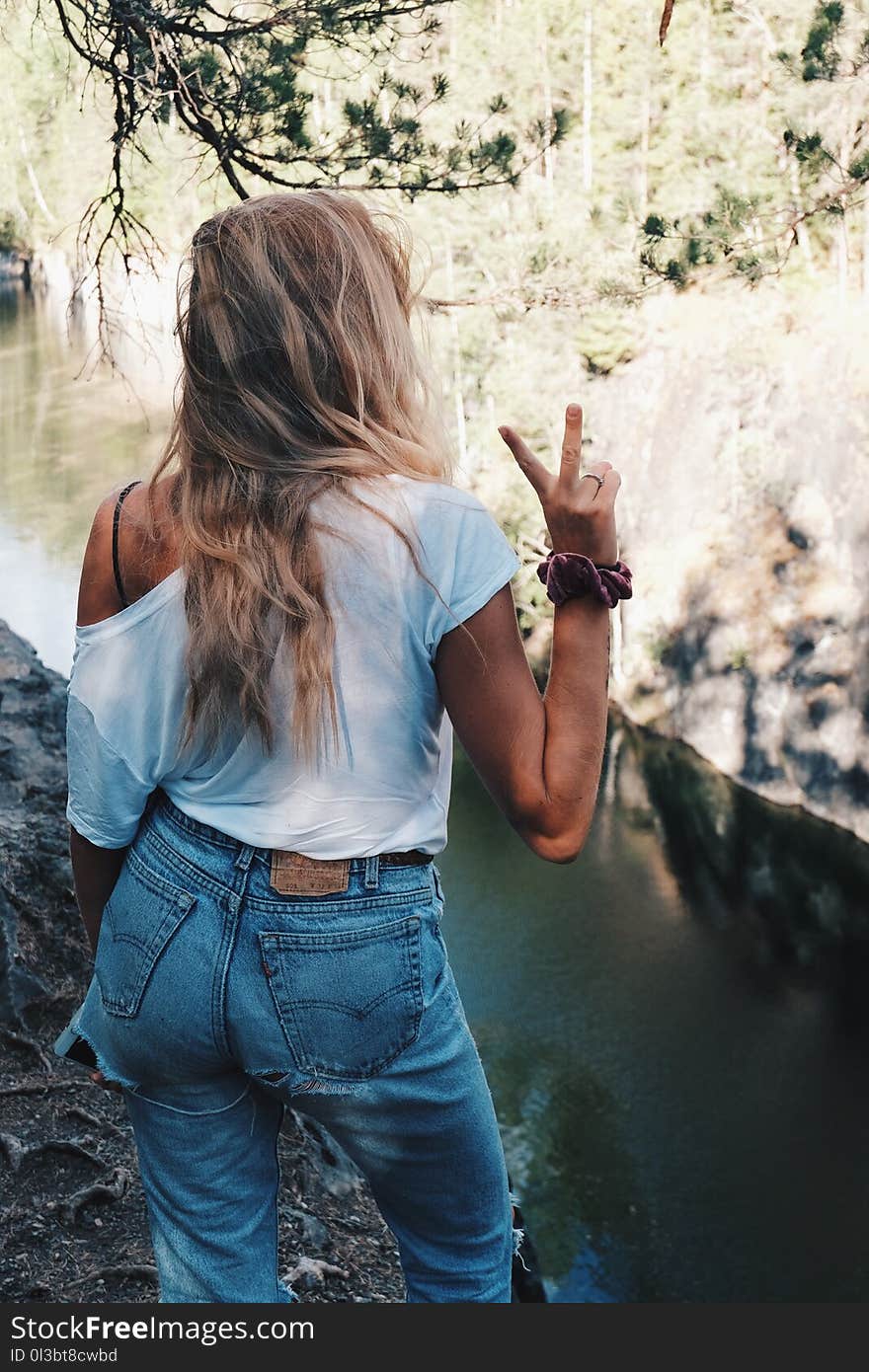 Woman in White Shirt Standing over the River Bank