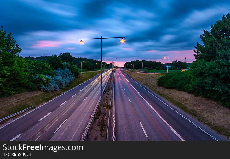 Setting sun and mvoing clouds with light trails in the road to osloGothenburg,Sweden. Setting sun and mvoing clouds with light trails in the road to osloGothenburg,Sweden