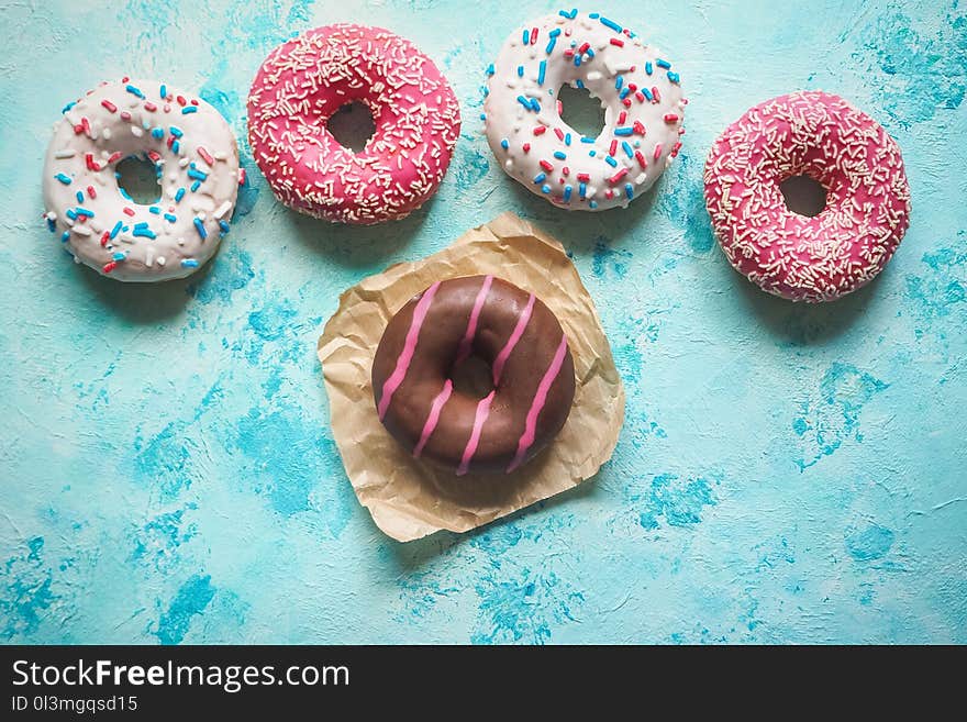 Colorful donuts on blue stone table. Top view.