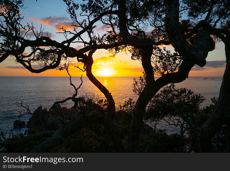 Pacific sunrise illuminates the sea with golden and red glow from base of Mount Maunganui. Pacific sunrise illuminates the sea with golden and red glow from base of Mount Maunganui.