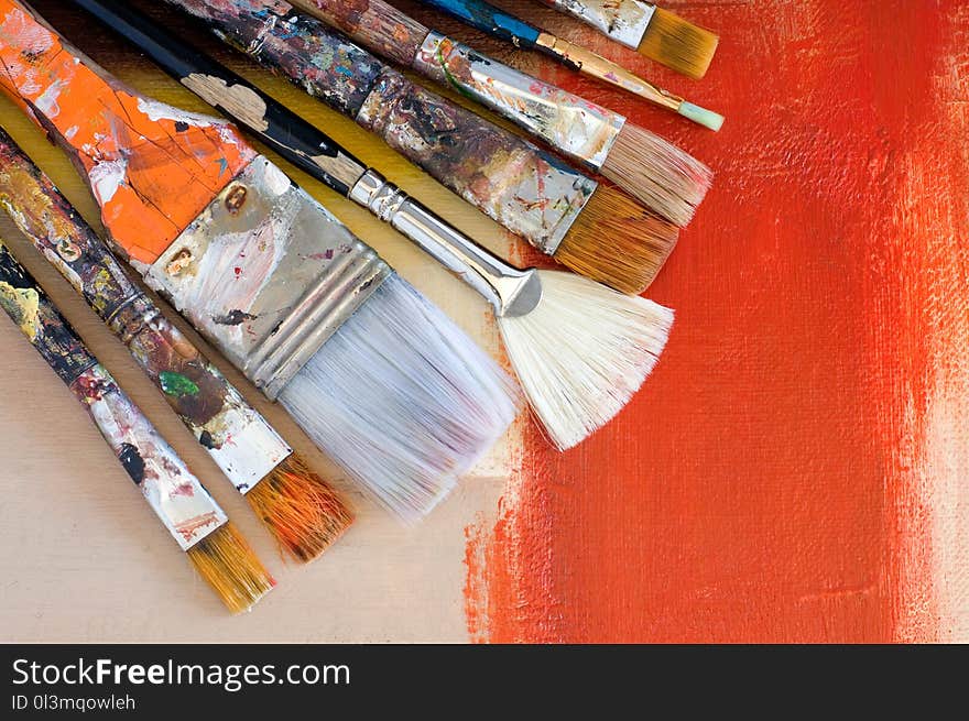 Various Old Paint Brushes on an Abstract Painting