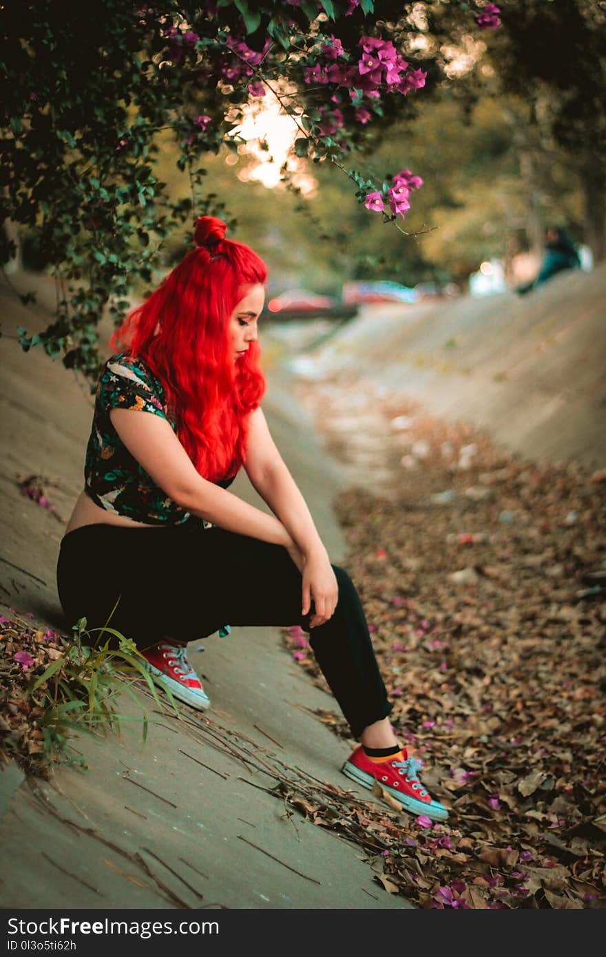 Woman Wearing Multicolored Cap-sleeved Crop Top and Black Pants on Concrete Pavement Under Purple Bougainvillea Flowers