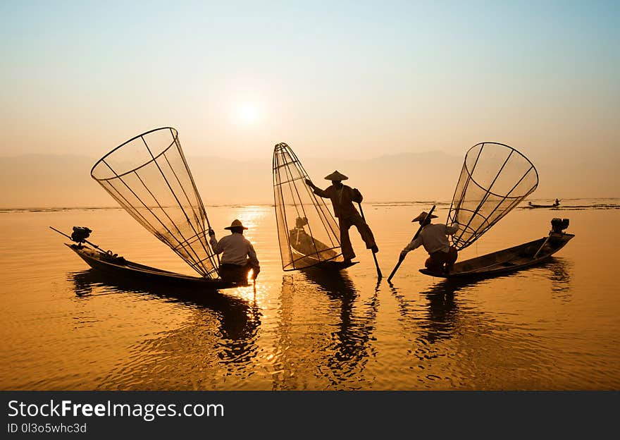 Three Men Riding Boats on Body of Water