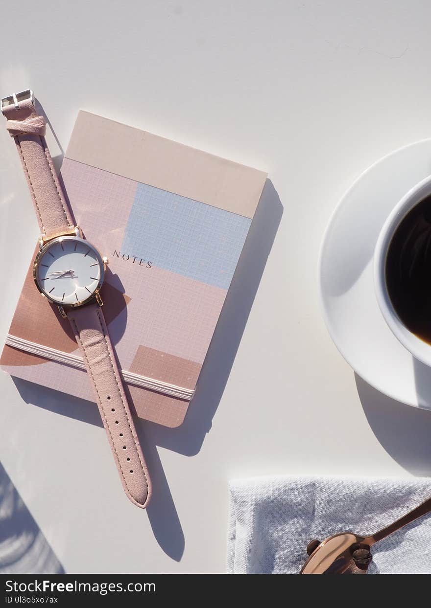 Round Gold-colored Analog Watch With Pink Leather Strap on Pink Notebook