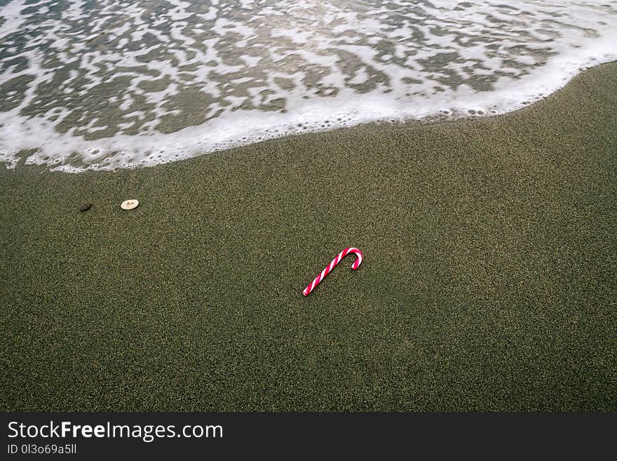 White and Red Christmas Candy on Beach Sand