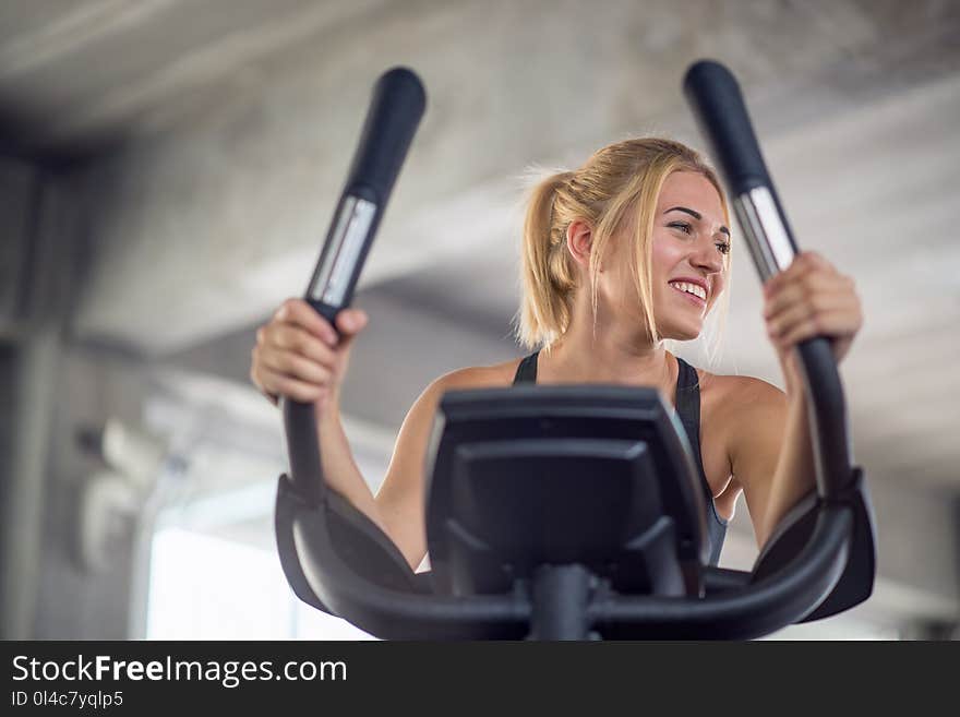 Portrait of young woman exercising on cardio machines in the gym. Portrait of young woman exercising on cardio machines in the gym