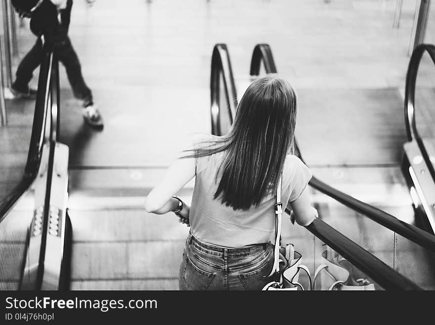 Monochrome Photography of Woman on the Escalator