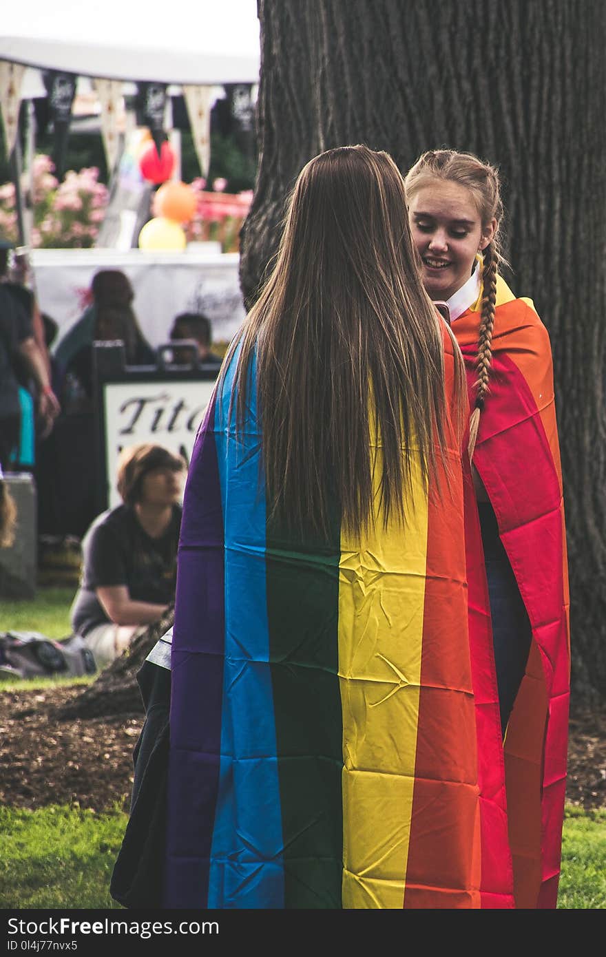 Photo of Two Woman Wearing Rainbow Capes