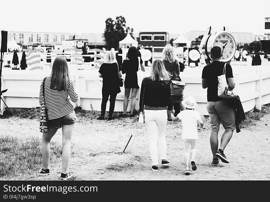 Grayscale Photo of People Gathering Near Clock