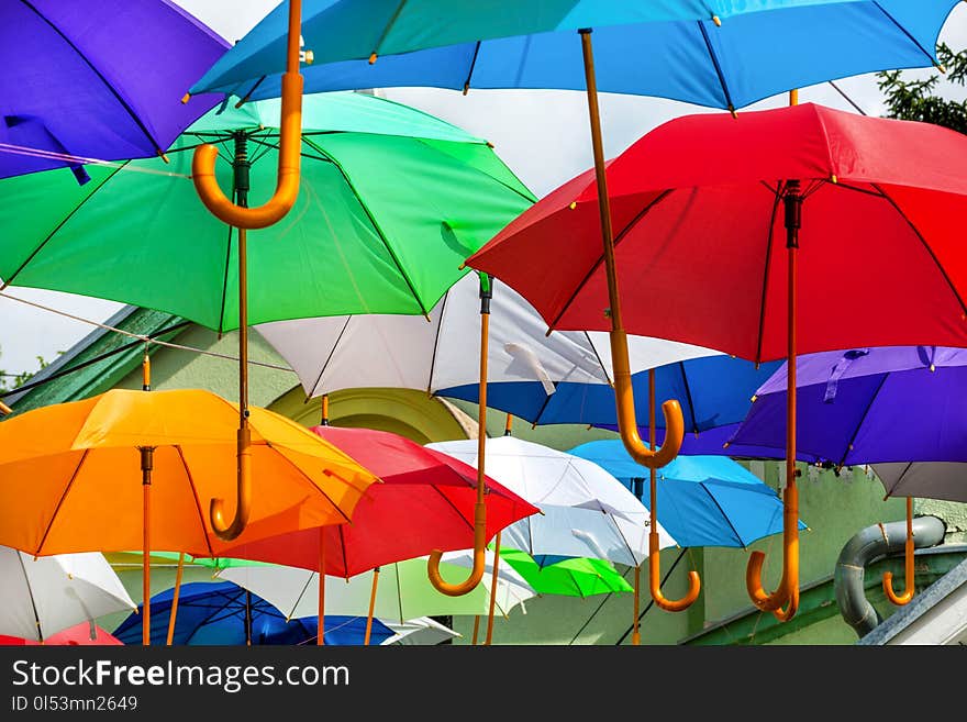 This captivating image showcases a delightful urban street adorned with a multitude of colorful umbrellas suspended overhead, creating a whimsical and eye-catching display. Against the backdrop of a clear blue sky, the vibrant umbrellas create a lively and joyful atmosphere, adding a burst of color and charm to the scene. The selective focus draws attention to the intricate details and textures of the umbrellas, while the close-up perspective allows viewers to appreciate their beauty up close. This popular tourist attraction is a visual feast for the senses, offering a unique and memorable experience for visitors. The combination of the colorful umbrellas and the radiant sunlight evokes a sense of warmth and happiness, making it a perfect image for concepts related to travel, tourism, outdoor events, urban life, and cheerful ambiance. This captivating image showcases a delightful urban street adorned with a multitude of colorful umbrellas suspended overhead, creating a whimsical and eye-catching display. Against the backdrop of a clear blue sky, the vibrant umbrellas create a lively and joyful atmosphere, adding a burst of color and charm to the scene. The selective focus draws attention to the intricate details and textures of the umbrellas, while the close-up perspective allows viewers to appreciate their beauty up close. This popular tourist attraction is a visual feast for the senses, offering a unique and memorable experience for visitors. The combination of the colorful umbrellas and the radiant sunlight evokes a sense of warmth and happiness, making it a perfect image for concepts related to travel, tourism, outdoor events, urban life, and cheerful ambiance.