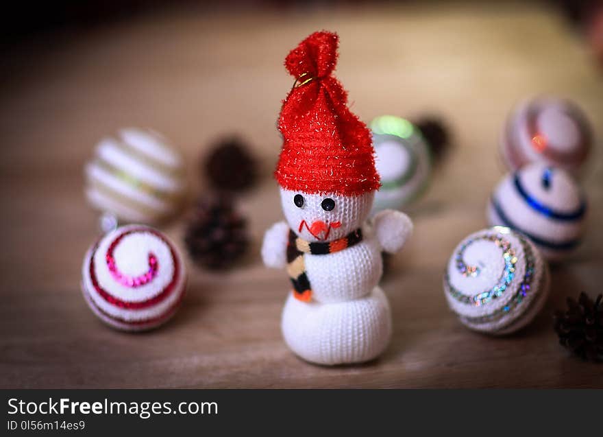 Toy snowman and gingerbread house at the Christmas table