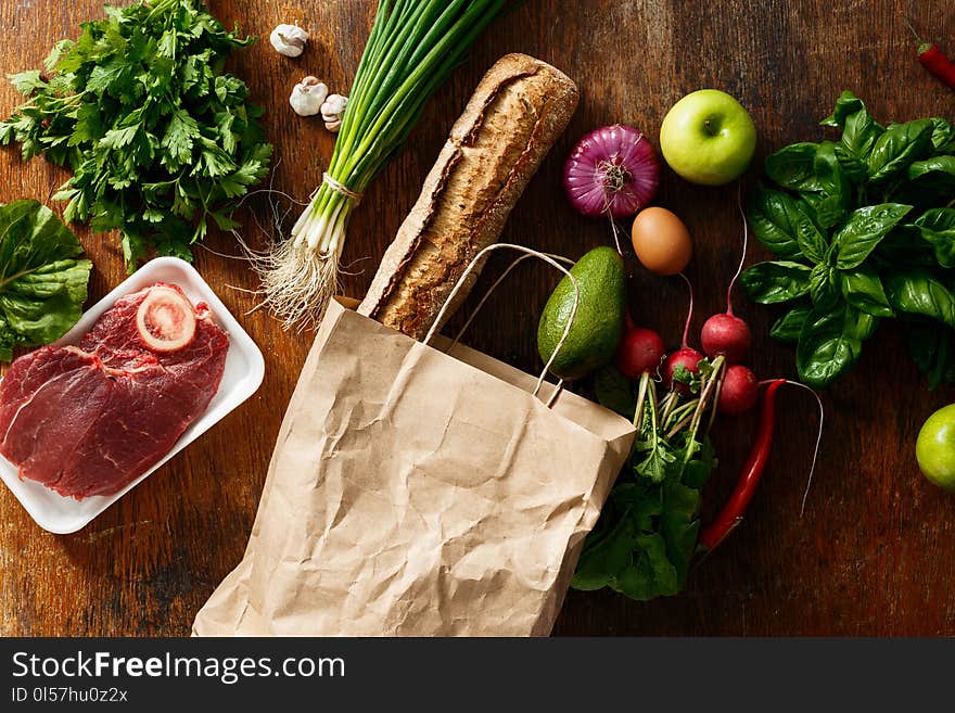 Paper bag with set different health food on wooden table. Top view. Flat lay. Paper bag with set different health food on wooden table. Top view. Flat lay