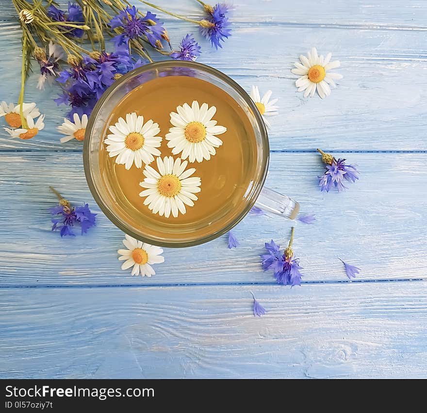 Chamomile tea cornflower on a wooden background summer morning. Chamomile tea cornflower on a wooden background summer morning