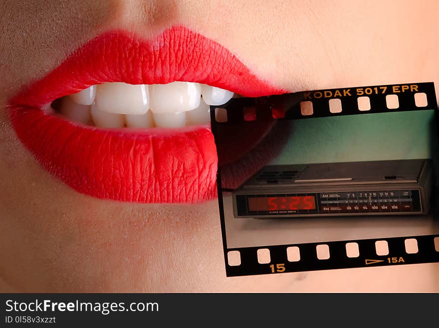 Person Wearing Red Lipstick Biting Film