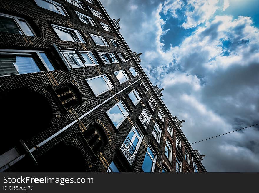 Brown Concrete Building Under Blue and White Cloudy Sky