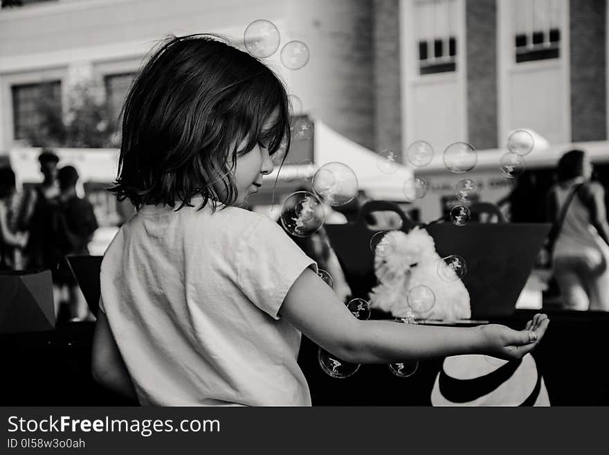 Monochrome Photography of Girl Playing With Bubbles