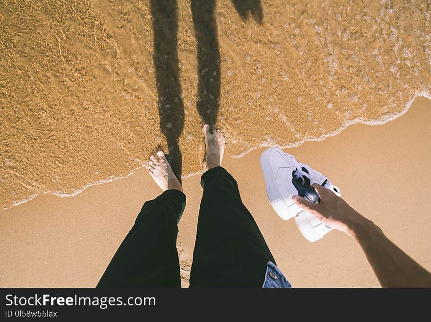 Photo of Person Holding Sneakers