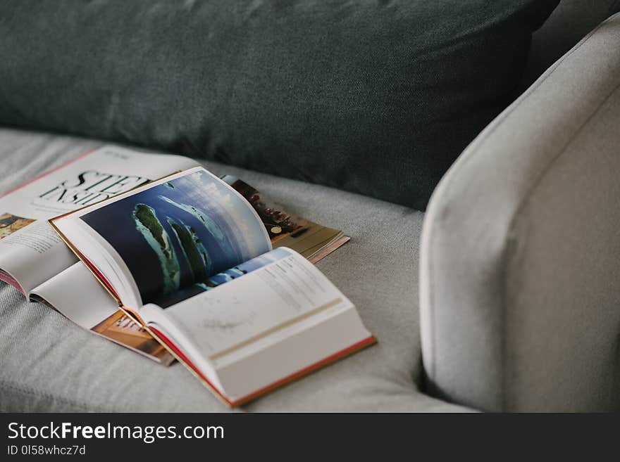 Red and White Reading Book on Gray Textile