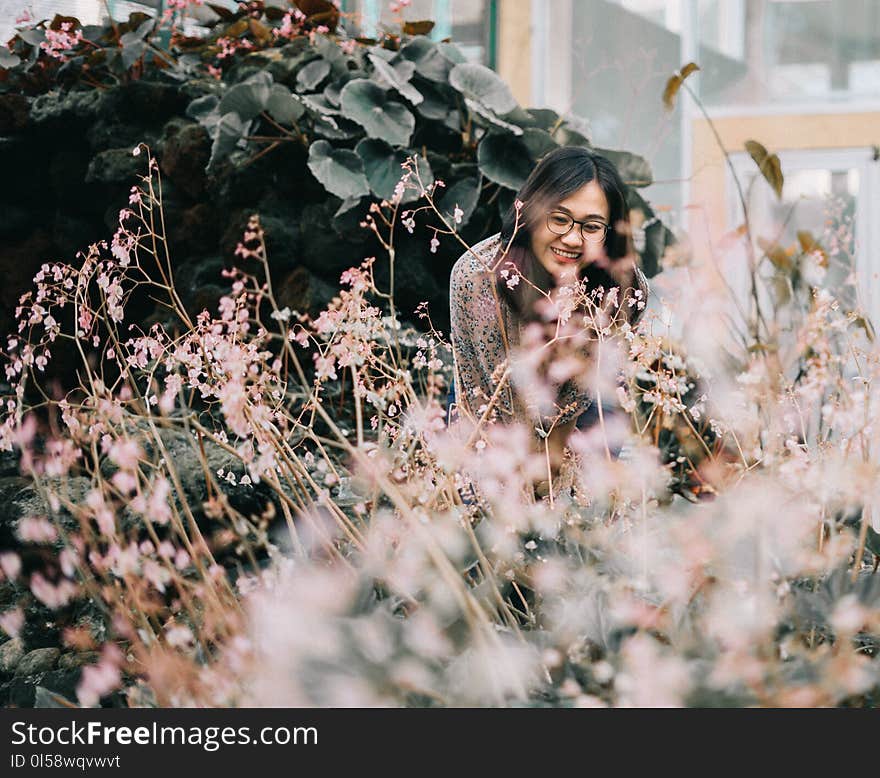 Woman Wearing Black Framed Eyeglasses Standing Near Flowers