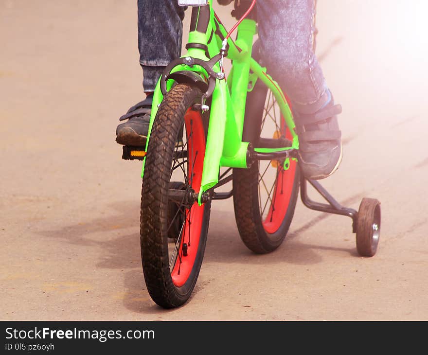 The boy`s feet on the children`s bike close in the summer, toned