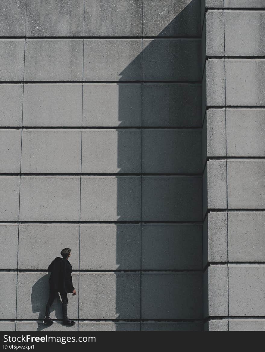 Photo of Man Standing on Concrete Building