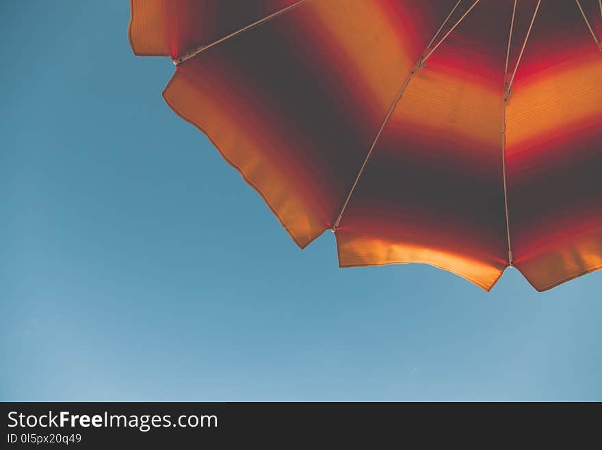 Low Angle Photography of Black and Orange Beach Umbrella