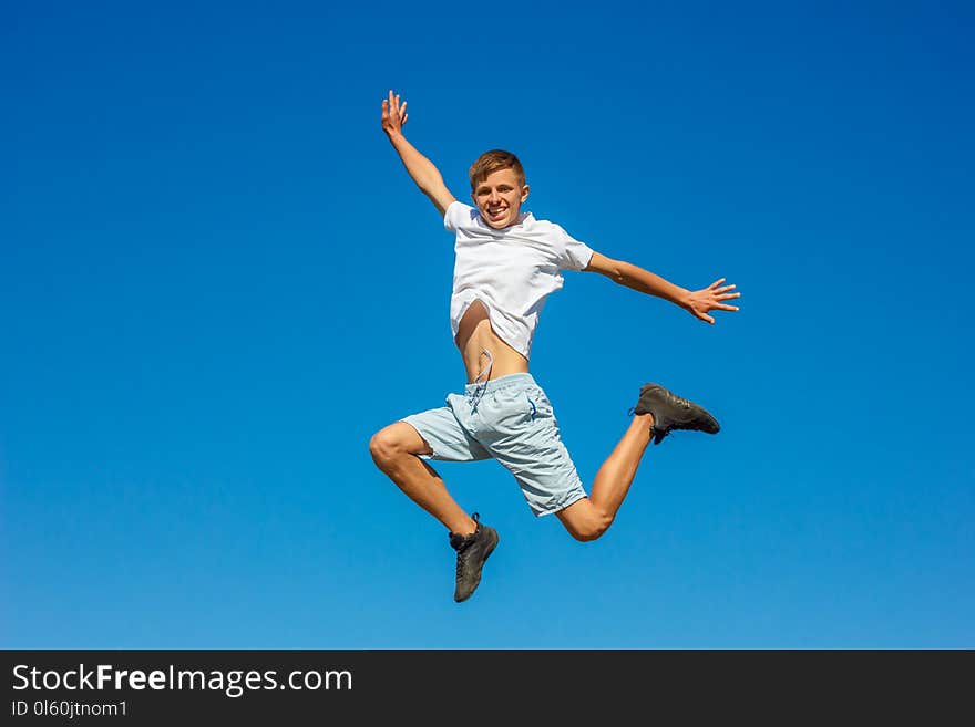 Happy boy jumping in the blue sky , concept of happiness/