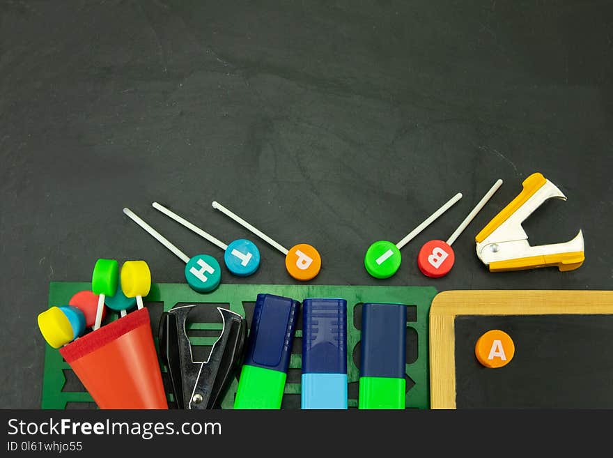 Closeup of colorful school supplies with copy space on blackboard background. Back to school.