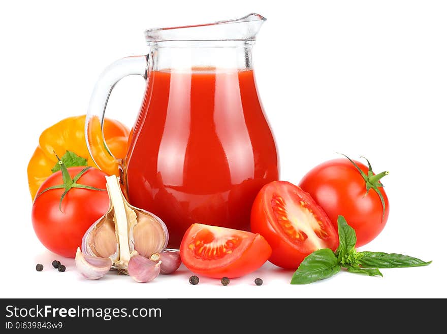 Tomato juice in glass jug with tomato, garlic, spices, and basil isolated on white background