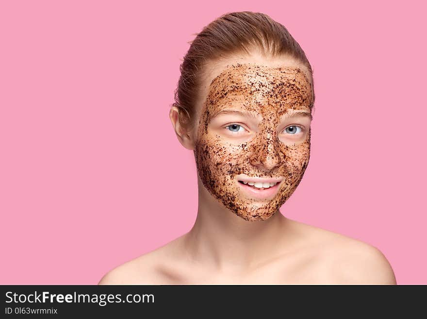 Face Skin Scrub. Portrait Of Smiling Female Model Applying Natural Coffee Mask, Face Scrub On Facial Skin. Closeup