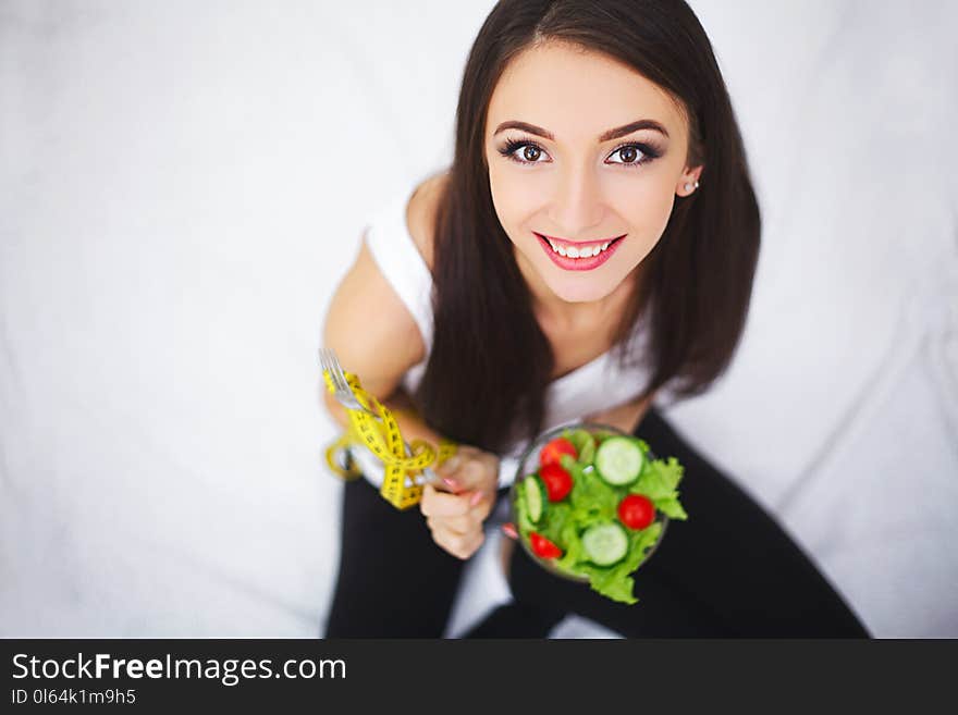 Diet. Woman Measuring Body Weight On Weighing Scale Holding Donu