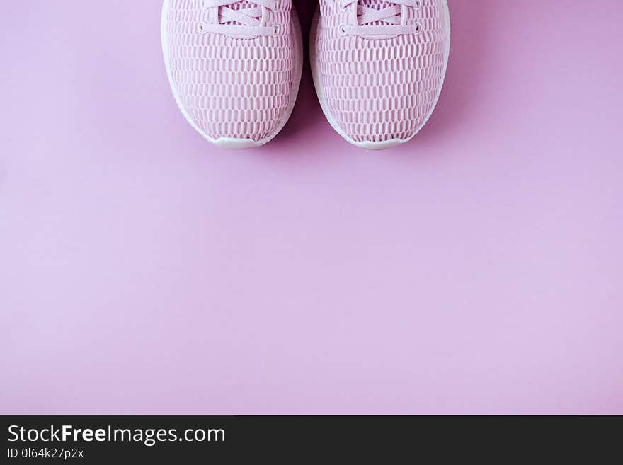 Violet sneakers, headphones and watches. Lay flat style Pink background. Violet sneakers, headphones and watches. Lay flat style Pink background.