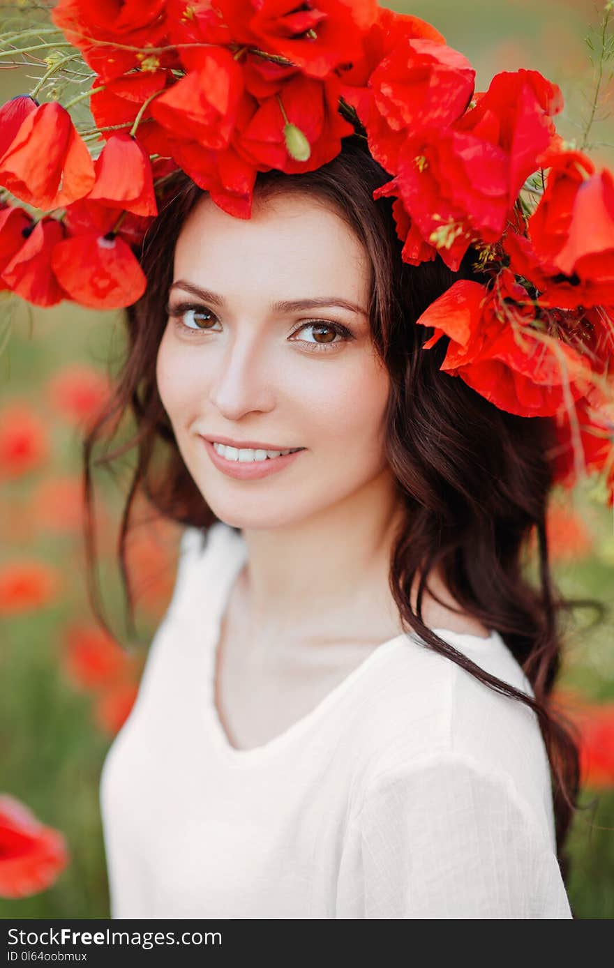 Beautiful girl in red poppy field. Beauty female Outdoor portrait. Freedom concept. Enjoyment.