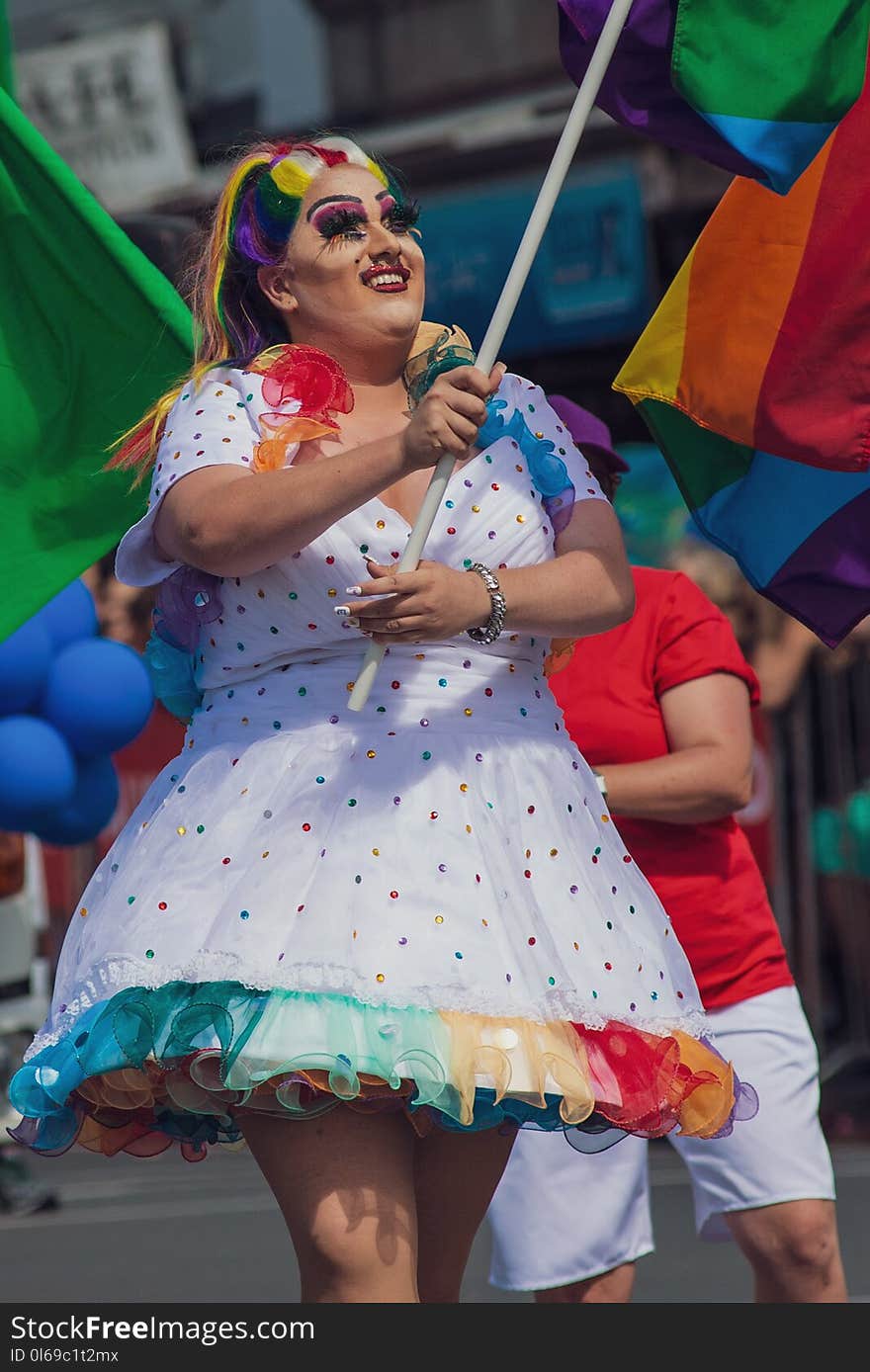 Woman in Multicolored Polka-dot Dress Holding Flag