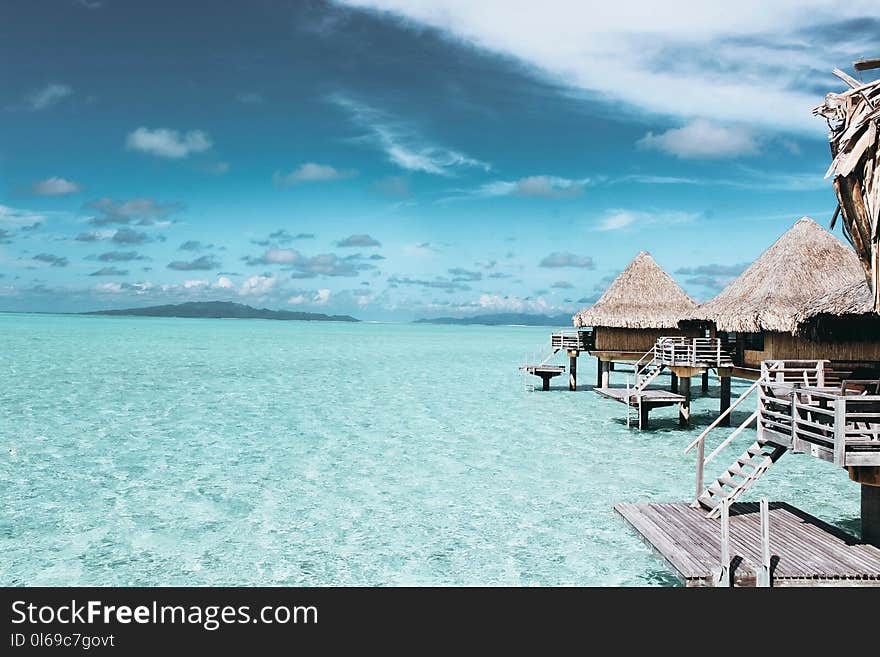 Three Brown Wooden Cottage and Sea